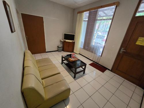 a living room with a couch and a coffee table at Kusma Hotel Bandungan Semarang in Semarang