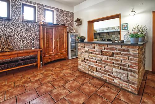 a kitchen with a brick wall and a brick fireplace at Penzion Vinařství Červinka in Horní Věstonice