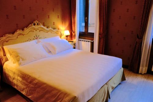 a bedroom with a large bed with a white bedspread at H O T E L S A N G A L L O l in Venice