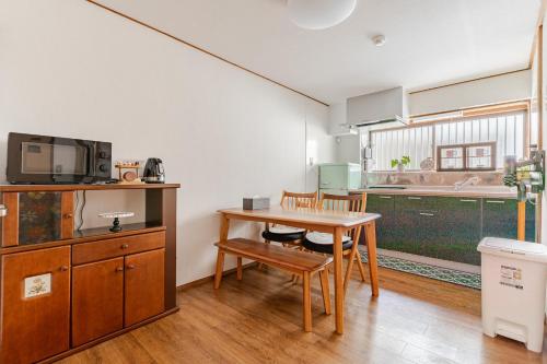 a living room with a table and a kitchen at 心斎橋から7分 なんばまで1駅 MeenoHome 幸せをひとりじめできる一軒家 空港直通 子ども歓迎 in Osaka