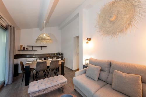 un salon avec un canapé et une table dans l'établissement Appartement 6 pers Jardin Privé La Cabane Bambou - Mandara Beach , Antibes French Riviera, à Juan-les-Pins