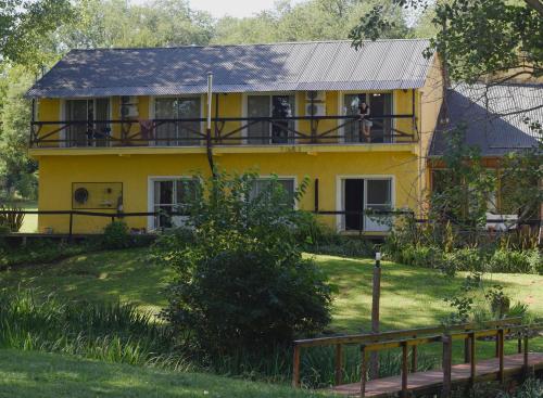 a yellow house with people on the balcony at Posada Quellen in Villa General Belgrano
