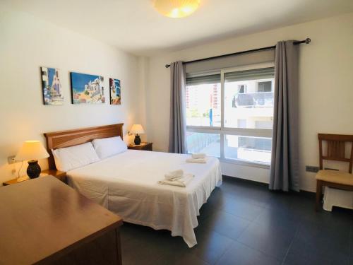 sypialnia z łóżkiem i dużym oknem w obiekcie La Manga Beach Club Frontal by Alina365 w mieście La Manga del Mar Menor