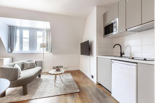 un salon avec un canapé et une cuisine dans l'établissement Arc de Triomphe - 2 people, à Paris