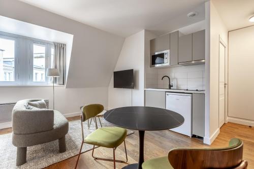 un salon avec une table et des chaises et une cuisine dans l'établissement Arc de Triomphe - 2 people, à Paris