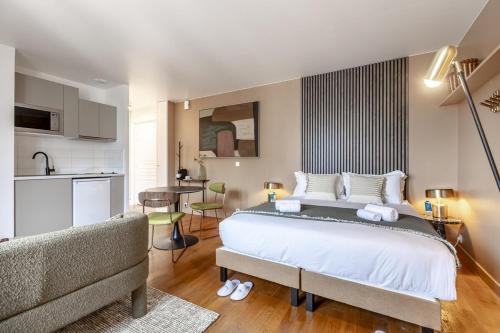 une chambre avec un grand lit et une cuisine dans l'établissement Arc de Triomphe - 2 people, à Paris