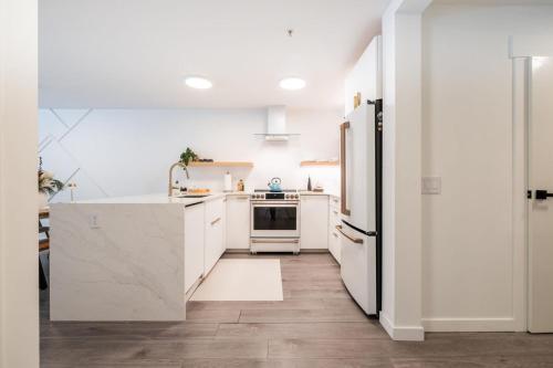 a kitchen with white cabinets and a refrigerator at Ravencrest by Outpost Whistler in Whistler