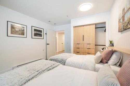 two beds in a bedroom with white walls at Ravencrest by Outpost Whistler in Whistler