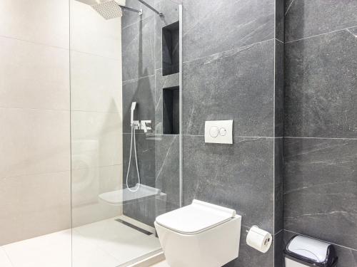 a bathroom with a toilet and a glass shower at VILLA 8 By ProLiving Hospitality in Thessaloniki