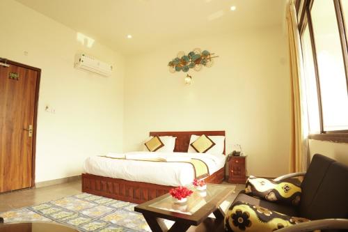 a bedroom with a bed and a living room at Golden Bird Pushkar in Pushkar