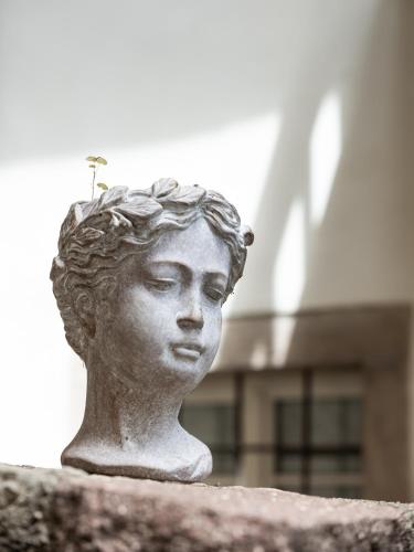a statue of a woman with a plant on her head at Romantik Hotel Jagdhof in Caldaro