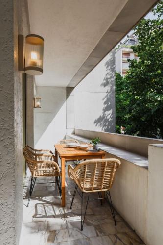 d'une terrasse avec une table en bois et 2 chaises. dans l'établissement Exceptional flat - 1BD 6P- Arc de Triomphe, à Paris