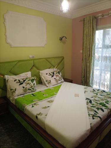 a bed in a room with a green couch at Menat Hôtel in Yaoundé