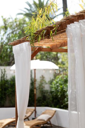 a white table with chairs and an umbrella at Appartement Jardin La Bohémienne du Mandara Beach , Juan-les-Pins, Cote d Azur in Juan-les-Pins