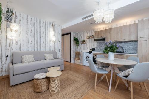 a living room with a couch and a table at Appartement Jardin La Bohémienne du Mandara Beach , Juan-les-Pins, Cote d Azur in Juan-les-Pins