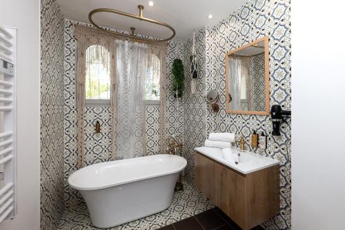 a bathroom with a tub and a sink and a mirror at Appartement Jardin La Bohémienne du Mandara Beach , Juan-les-Pins, Cote d Azur in Juan-les-Pins