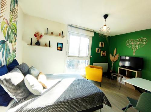 ein Schlafzimmer mit einem Bett und einer grünen Wand in der Unterkunft Hesperie studio in Chamalières