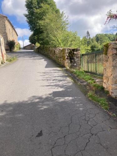 an empty road next to a stone wall at Gite de l'Entressac in Pradelles