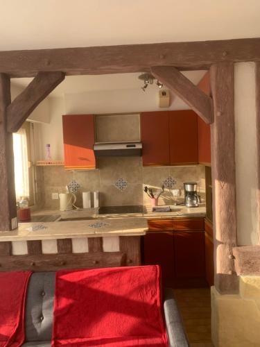 - une cuisine avec un canapé rouge dans une chambre dans l'établissement Studio Kennedy, à Trouville-sur-Mer
