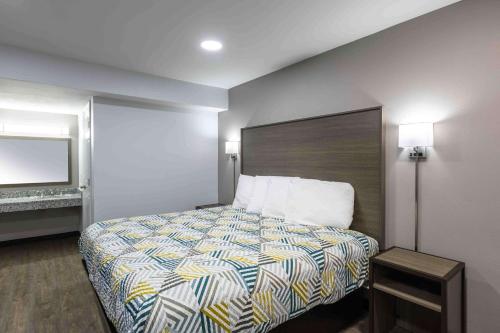 a hotel room with a bed and a mirror at Motel 6 Hickory NC in Hickory