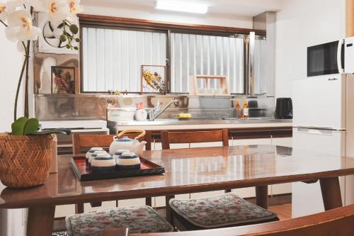 a kitchen with a table with chairs and a refrigerator at 心斎橋まで7分 なんば1駅 Meeno Home 汐見 一軒家貸切 子ども歓迎 in Osaka