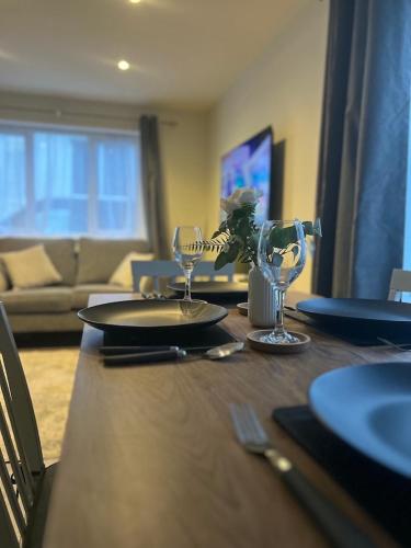 a dining room table with glasses and a couch at Church Mews Central Townhouse West Hoe Plymouth in Plymouth