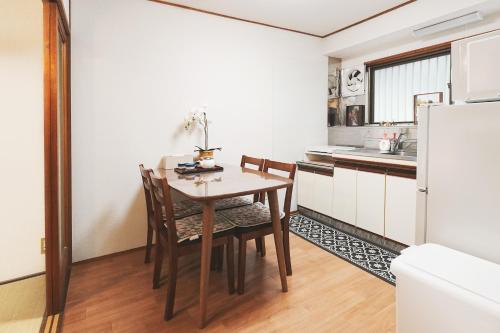 a kitchen with a table and chairs and a refrigerator at 心斎橋まで7分 なんば1駅 Meeno Home 汐見 一軒家貸切 子ども歓迎 in Osaka