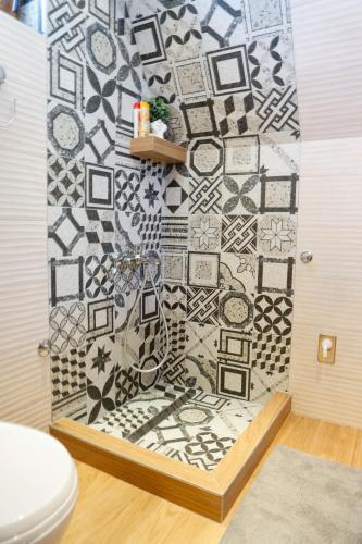 a bathroom with a shower with a mosaic wall at Vikendica Monte Pino Romanija in Sokolac
