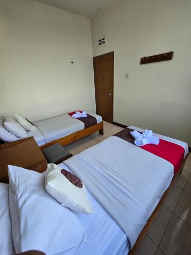 a room with three beds in a room at Kusma Hotel Bandungan Semarang in Semarang