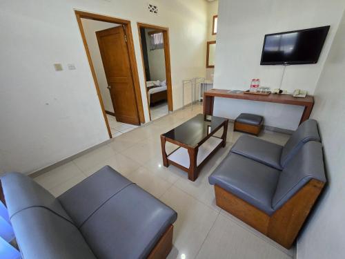 a living room with a couch and chairs and a television at Kusma Hotel Bandungan Semarang in Semarang