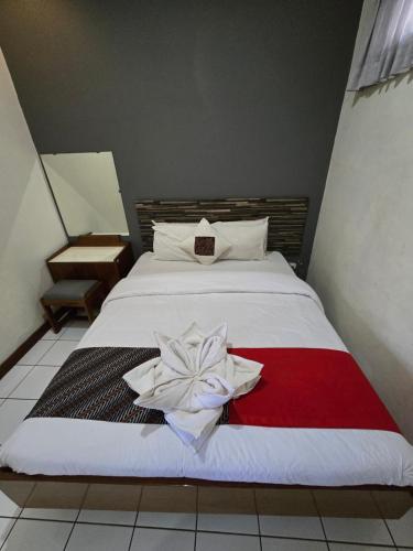a bedroom with a bed with a flower on it at Kusma Hotel Bandungan Semarang in Semarang
