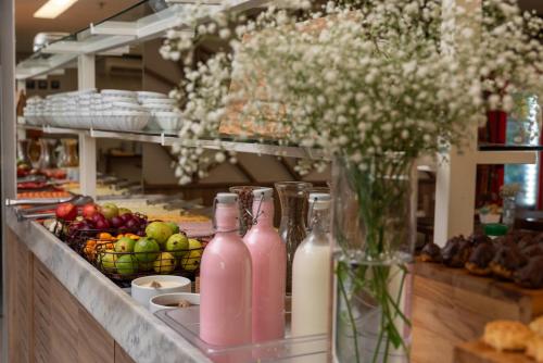 a counter with bottles of milk and a vase of flowers at Intercity Maceio in Maceió