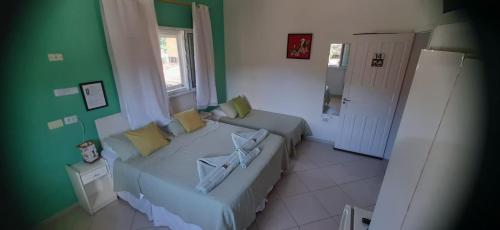 a living room with a couch and a green wall at Pousada Irashai in Juquei