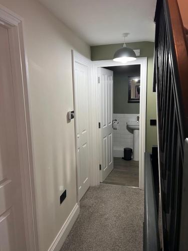 a bathroom with a hallway with a toilet and a door at Church Mews Central Townhouse West Hoe Plymouth in Plymouth