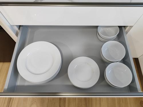 a tray with four white plates in a drawer at Apartamentos VALDECILLA nuevos in Santander