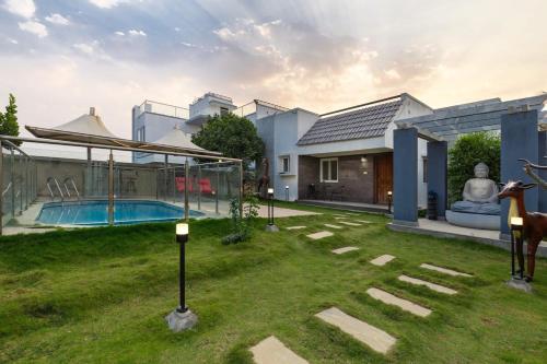 a villa with a swimming pool and a house at Blue Nest By StayJadeParty VillaLawn in Hosūr