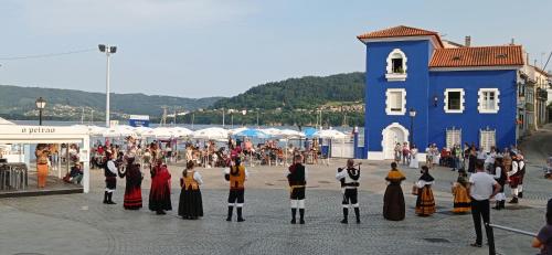 a group of people in costumes standing in a street at Paraíso Ortegal in Feás