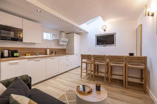 een keuken en woonkamer met een bank en een tafel bij MEY T2 - Superbe appartement 4 pers, 50m du vieux port et 2min à pied du palais in Cannes