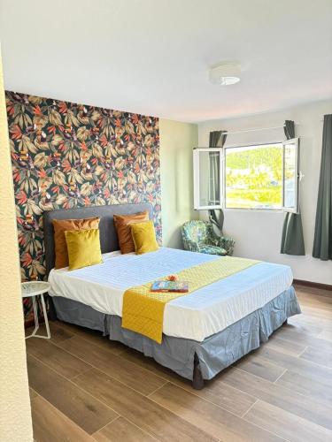a bedroom with a large bed with yellow pillows at Le Ti Marinois 5 in Le Marin
