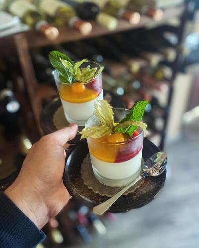a person holding three cocktails on a black plate at Zlatý Klas in Mariánské Lázně