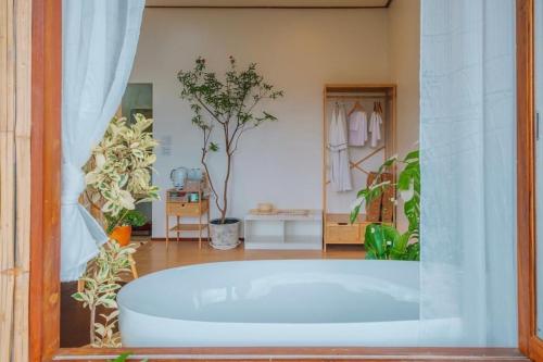 a large bath tub in a room with plants at Wintery House in Ban Thung Phan Ha