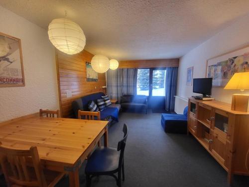 un salon avec une table et un canapé dans l'établissement Appartement central Montgenèvre avec jardin, parking, et commodités pour 6 personnes - FR-1-266-122, à Montgenèvre