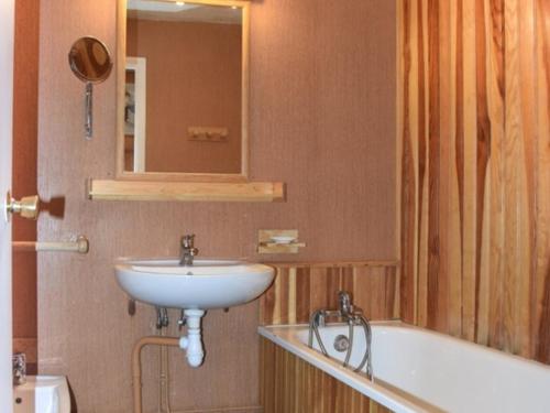 une salle de bain avec un lavabo et une baignoire dans l'établissement Appartement central Montgenèvre avec jardin, parking, et commodités pour 6 personnes - FR-1-266-122, à Montgenèvre