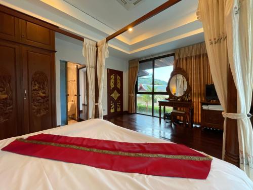 a bedroom with a bed with a mirror and a piano at Вилла в сердце Пхукета in Ban Lum Fuang