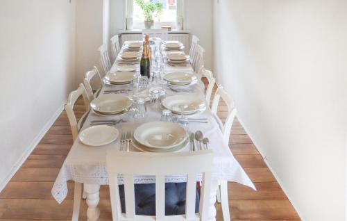 a long white table with white plates and wine bottles at Gorgeous Home In Diever With Wifi in Diever