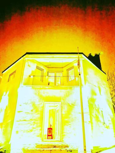 a yellow house with a red chair in the doorway at Spa Apartment Family Belgrad in Brestovik