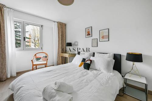 ブローニュ・ビヤンクールにあるGaspar- 2 Rooms with Balcony- Metro Marcel Sembatの大きな白いベッドと椅子のある寝室