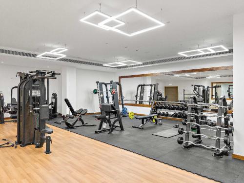 a gym with several treadmills and weights at Silkhaus Premium 1BR at Soho Square in Saadiyat in Abu Dhabi