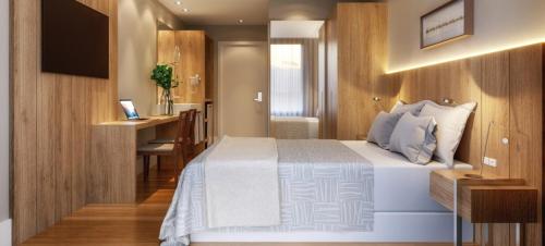 a bedroom with a bed and a desk and a television at Golden Tulip Canela in Canela