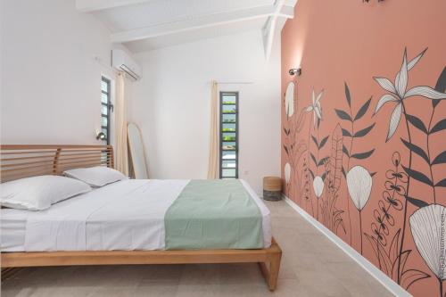 una camera con letto e parete floreale di Bungalow Visão a Sainte-Anne